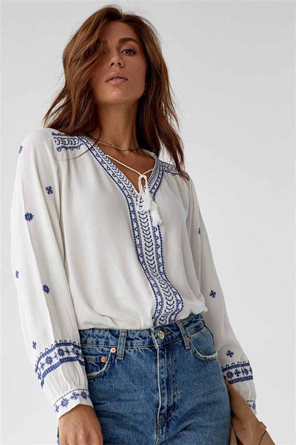 Blusa blanca minimalista bordada en azul