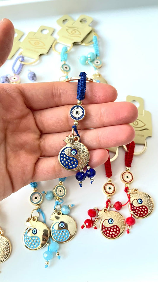 Llavero de ojo turco dorado con diseño de abundancia de granada azul oscuro