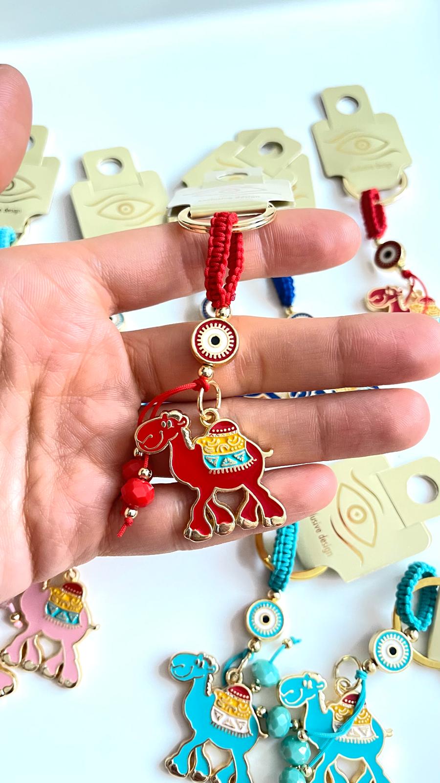 Llavero con diseño de camello rojo y ojo turco dorado