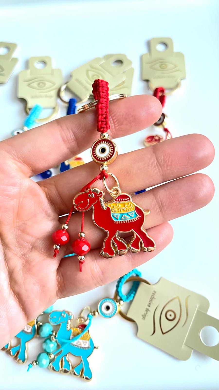 Llavero con diseño de camello rojo y ojo turco dorado