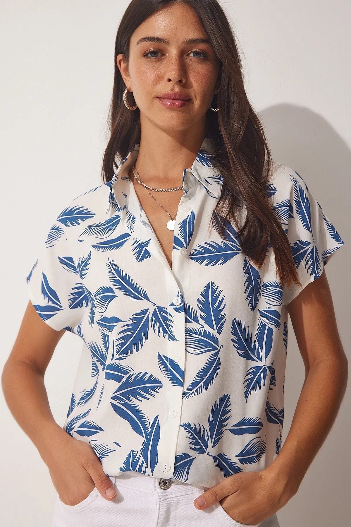 Blusa blanca de manga corta con hojas azules