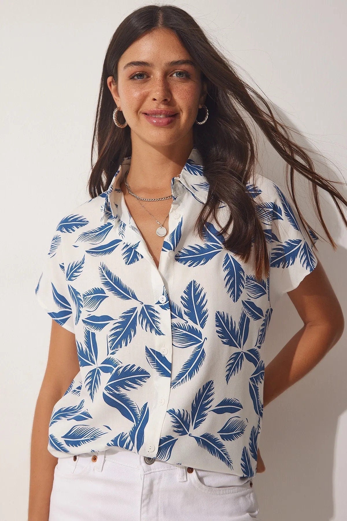 Blusa blanca de manga corta con hojas azules