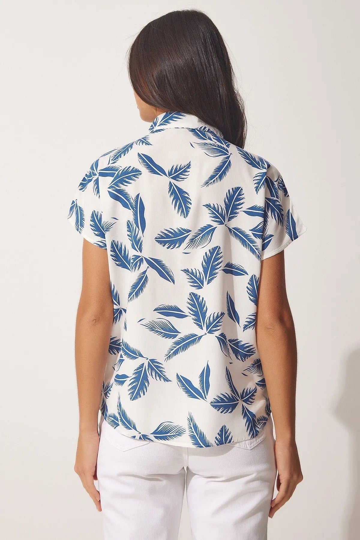 Blusa blanca de manga corta con hojas azules